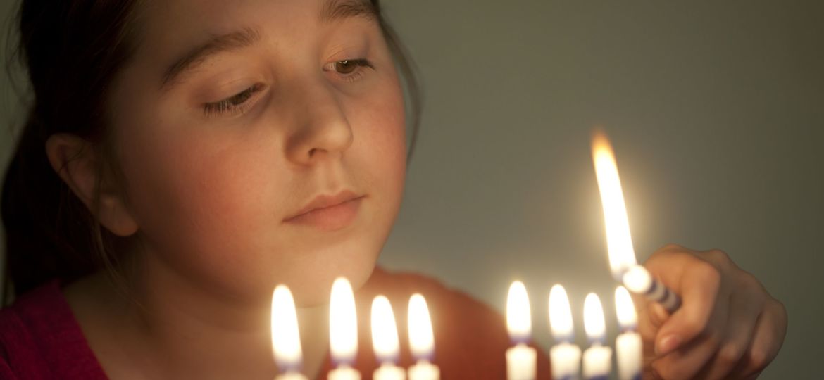 Girl lights menorah